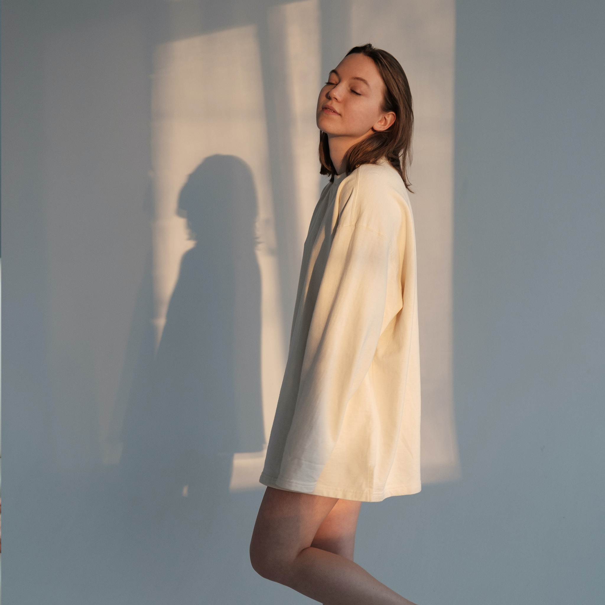 00_lichtfiltering_vrouw_staand_genieten_van_binnenvallende_zon_2048x2048